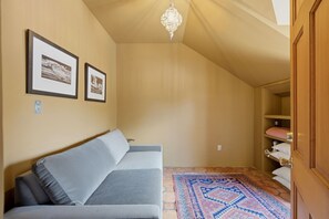 Une pièce chaleureuse avec un canapé, un tapis à motifs et une porte en bois.