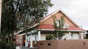 A building with a red roof and beige walls, a sign indicating 'The Paradox', and a gravel driveway.