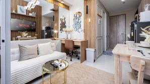 Una sala moderna con un sofá, una mesa de centro y un televisor mostrando 'NETFLIX'.