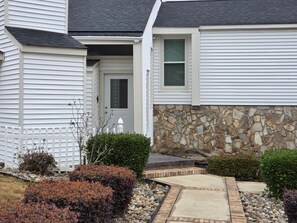 A house with a stone facade, a front door, and a small garden with shrubs and a pathway. - 3 BR, Pool, Housekeeping, Grounds Maint  & Utilities (Augusta)