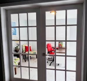 A room with a white door, a desk, a red chair, and a plant. - Walk to Augusta National w/Pool, Housekeeping & Utilities (Augusta)
