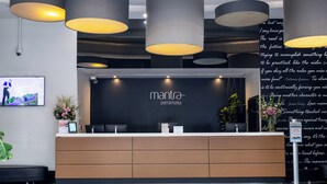 Una reception con una insegna nera che riporta “manta parramatta”, un televisore a schermo piatto montato al muro e un tappeto a motivi.