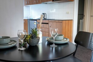 A dining table with a plant, a candle, and wine glasses. - Modern 1BR Apartment Walk to Station & Westfield Pool Wi-Fi Parramatta CBD (Parramatta)