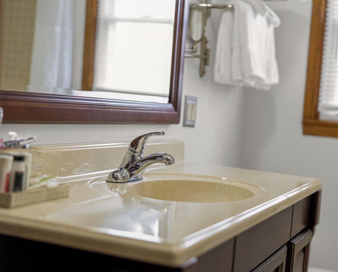 A bathroom with a sink, mirror, and towel rack.