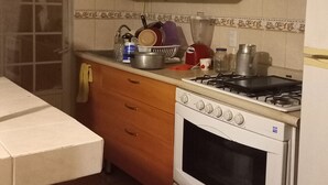 Une cuisine équipée d’une cuisinière, d’un four et de divers ustensiles de cuisine disposés sur le plan de travail.