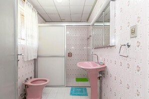 Une petite salle de bain avec des toilettes, un lavabo et une douche.