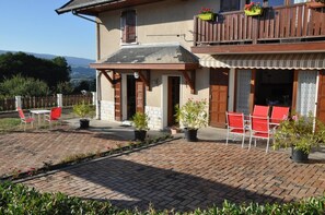 A two-story house with a patio area, outdoor seating, and potted plants. - LA LANSADIERE - SAINT GIROD (SAINT GIROD)