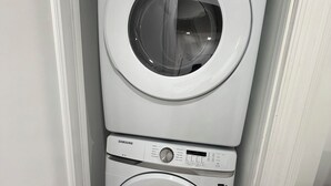 Lavadora y secadora Samsung de carga frontal apiladas en un espacio reducido.