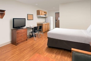 A hotel room with a bed, a desk with a chair, a television, a microwave, and a refrigerator. - Woodspring Suites Clarksville Ft Campbell (Clarksville)