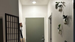 A hallway with a sliding door, a shoe rack, and wall-mounted planters. - Cozy studio apartment in charming St. Petersburg perfect for your getaway. (St. Petersburg)