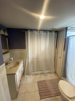 Ein Badezimmer mit Dusche, Toilette, Waschbecken und Spiegel.