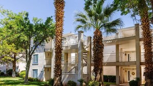 A multi-story building with balconies, palm trees, and a clear sky. - Remodeled End Unit | Family Amenities | #609 (Saint George)