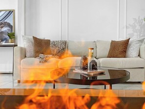 Un salon moderne avec un canapé, une table basse et une cheminée.