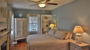A bedroom with a bed, a nightstand, a dresser, a chair, a bookshelf, and a globe on a cabinet. - Cozy Private Cottage in the Heart of Downtown Asheville - 300 5-star reviews! (Asheville)