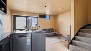 Una cocina moderna con lavavajillas, una isla integrada y un ventanal grande.