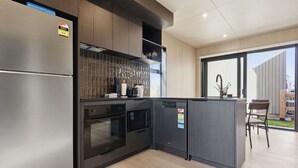 Una cocina moderna con electrodomésticos de acero inoxidable, lavavajillas y horno empotrado.