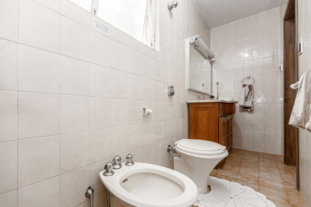 A bathroom with a toilet, bidet, and sink.