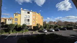 A multi-story residential building with a parking lot in front. - Lovely 2-room apartment for 4 people in Mt St Martin near the port of Cap d'Agde (LE CAP D AGDE)
