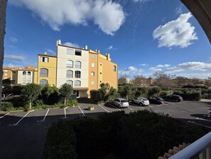 A multi-story residential building with a parking lot in front. - Lovely 2-room apartment for 4 people in Mt St Martin near the port of Cap d'Agde (LE CAP D AGDE)