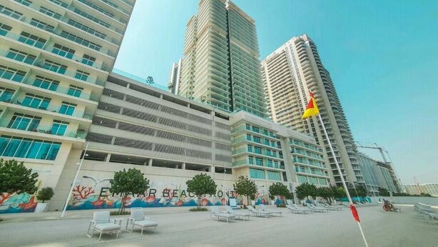 Un hotel moderno con varios edificios de gran altura, un mural con fauna marina y zonas de estar al aire libre.