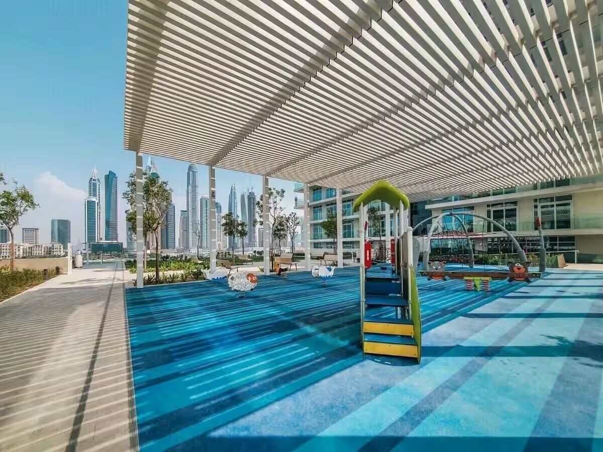 A rooftop pool area with a modern design, including a covered seating area and a children's play structure.