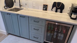 Una cocina con un lavamanos, un refrigerador y una cafetera.