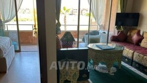 Ein Zimmer mit einem Bett, einem Schlafsofa, einem Fernseher und einem kleinen Tisch. Es gibt ein Fenster mit Vorhängen und einen Blick nach draußen.