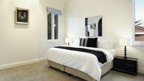 A bedroom with a bed, bedside tables, a window, and a wall-mounted artwork. - Luxurious Kew House - 5 min walk to cafes and restaurants (Kew)