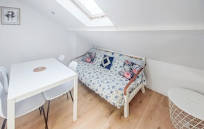 Ein Zimmer mit einem Bett, einem Tisch und Stühlen.