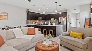 A modern kitchen with dark cabinets, a central island, and pendant lighting. - 🦩Book Me Baby! Seascape at PCB🦩 (Panama City)