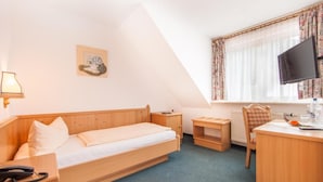 A single bedroom with a bed, bedside table, lamp, and a desk with a chair. - Hotel Restaurant Piccolo (Thale)