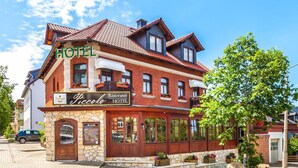 A two-story hotel with a stone facade and a red-tiled roof. - Hotel Restaurant Piccolo (Thale)