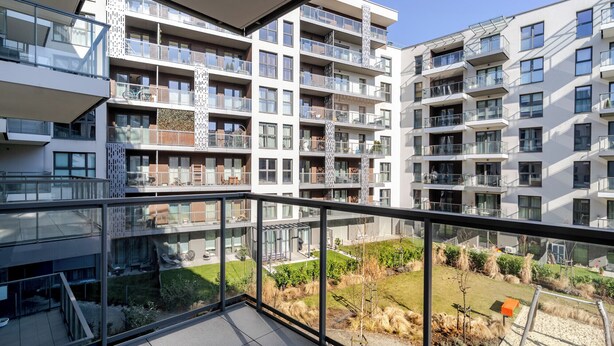 A modern apartment building with multiple balconies, large windows, and a view of a landscaped garden. - Szybowcowa Charming Apartment (Katowice)