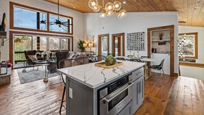 A spacious kitchen with a large island, wooden ceiling, and large windows. - Blue Ridge Retreat - Lakefront | Dock | Firepit | Game Room (Blue Ridge)