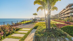 A coastal residential area with a paved walkway, landscaped gardens, and a view of the sea. - III - Savoy Monumentalis, By Pausa Holiday Rentals (Funchal)