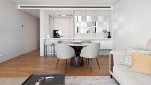 A modern living room with a dining area, featuring a sofa, a coffee table, and a dining table with chairs. - III - Savoy Monumentalis, By Pausa Holiday Rentals (Funchal)