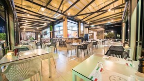 A spacious restaurant with high ceilings and natural light. Tables are arranged in a casual layout, and the interior features modern furnishings and a clean, well-lit atmosphere. - Marika Hotel Chania (Platanias)