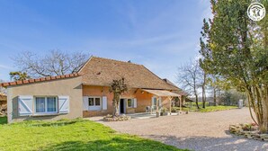 A two-story house with a tiled roof, a covered porch, and a gravel driveway. - Cosy Bresse - SAINT VINCENT EN BRESSE (SAINT VINCENT EN BRESSE)