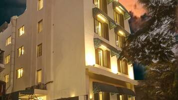 A multi-story hotel with a flat facade, multiple windows, and a gated entrance.