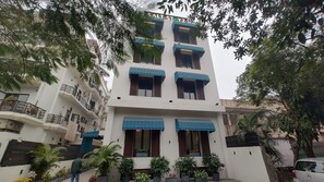 A multi-story building with balconies, a sign reading 'SALT STAYZ', and potted plants around the entrance. - Saltstayz Thyme (New Delhi)