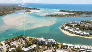 Una vista aerea di un resort costiero con diversi edifici, una marina e una spiaggia.