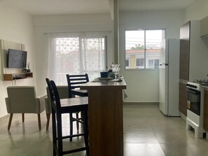 A modern kitchen with a dining area, a refrigerator, an oven, and a television on the wall. - Durei Refuge: Ideal for remote work with fast Wi-Fi! (Paraty)