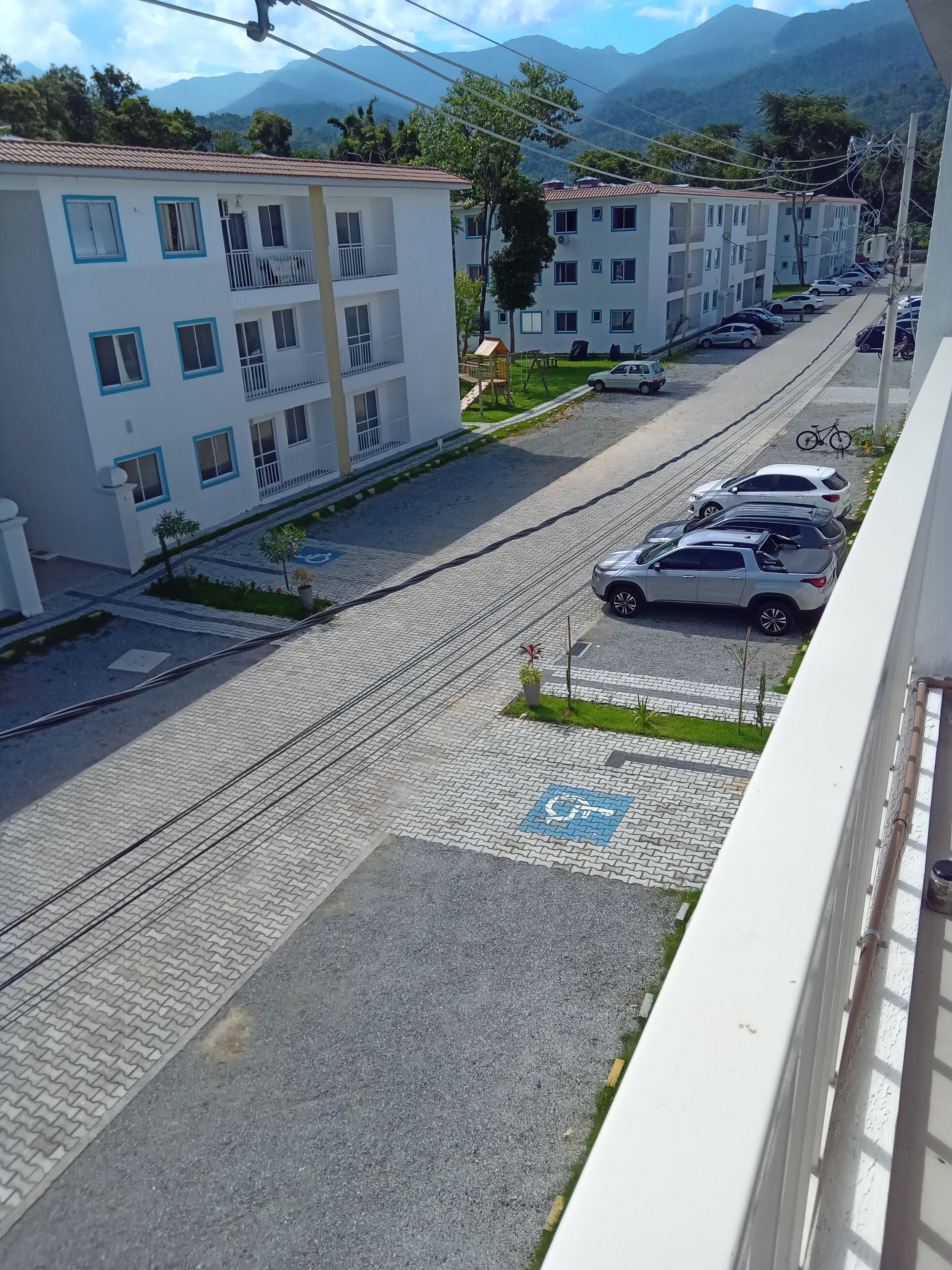 A residential area with multi-story buildings, a tram line, and parked cars.