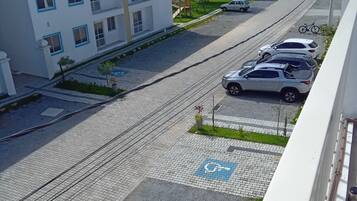 A residential area with multi-story buildings, a tram line, and parked cars.