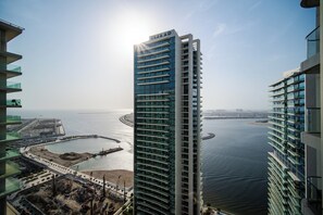 A high-rise building with a marina and waterfront view. - SettlerHomes, Emaar Beachfront Haven with Sea View (Dubai)