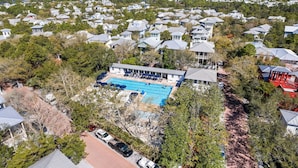 Et boligområde med huse, en swimmingpool og en stor bygning med en overdækket terrasse.