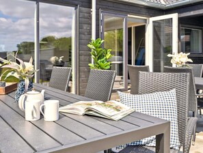 An outdoor patio with a table, chairs, and a book. - 5 Star Holiday Home in Bogense (Bogense)