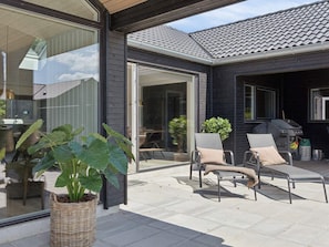 A modern house with a patio, outdoor seating, and a grill. - 5 Star Holiday Home in Bogense (Bogense)
