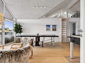 A modern kitchen with a dining table, a dog, and a large window. - 5 Star Holiday Home in Bogense (Bogense)