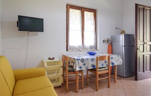A compact kitchen with a dining table, chairs, a television, and a refrigerator. - 2 bedroom lovely home in Punta Licosa (Punta Licosa)